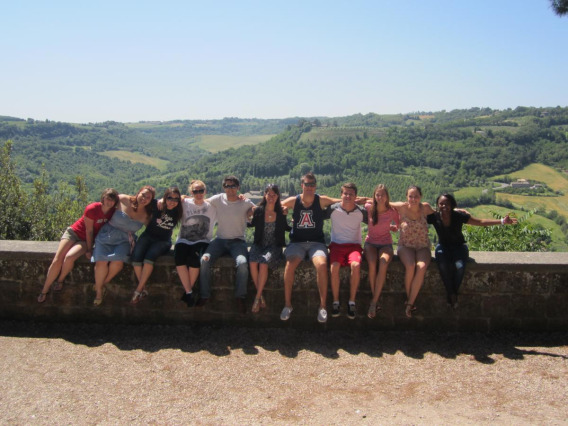 Study abroad students sitting on a wall.